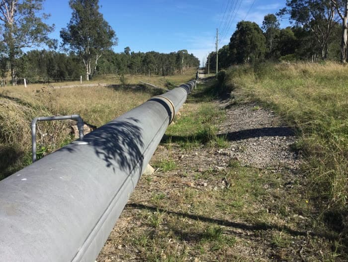 Large-diameter pipeline running above ground through open land