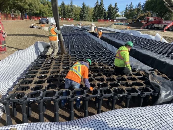 Crew installing a modular underground stormwater detention chamber system
