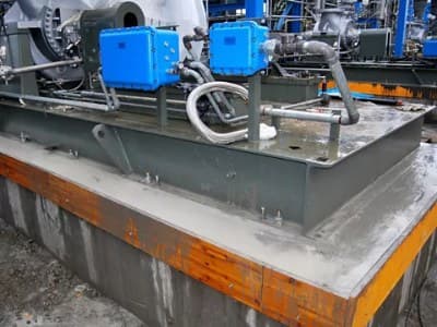 Industrial equipment skid mounted on a grouted steel base plate