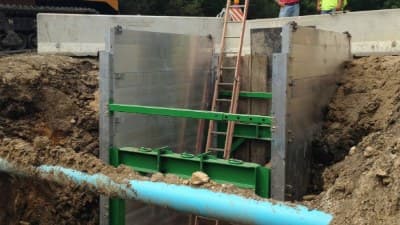 Deep trench braced with aluminum hydraulic shoring panels and a ladder