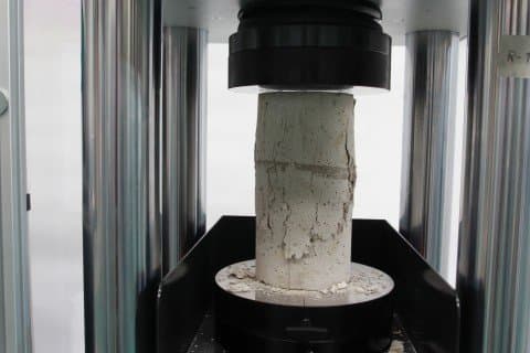 Concrete cylinder in a compression testing machine