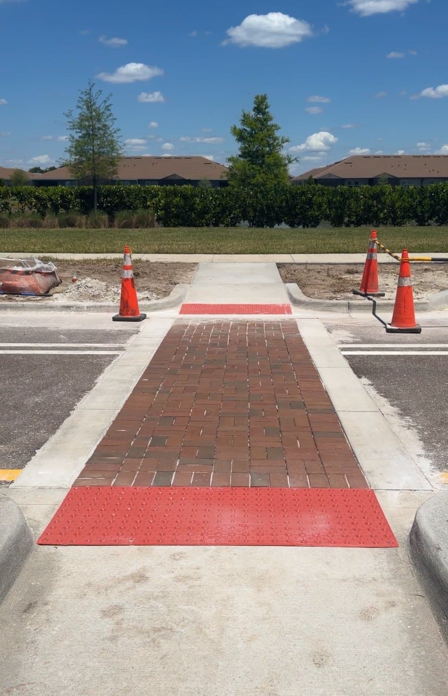 Freshly placed rapid set concrete sidewalk section marked with traffic cones