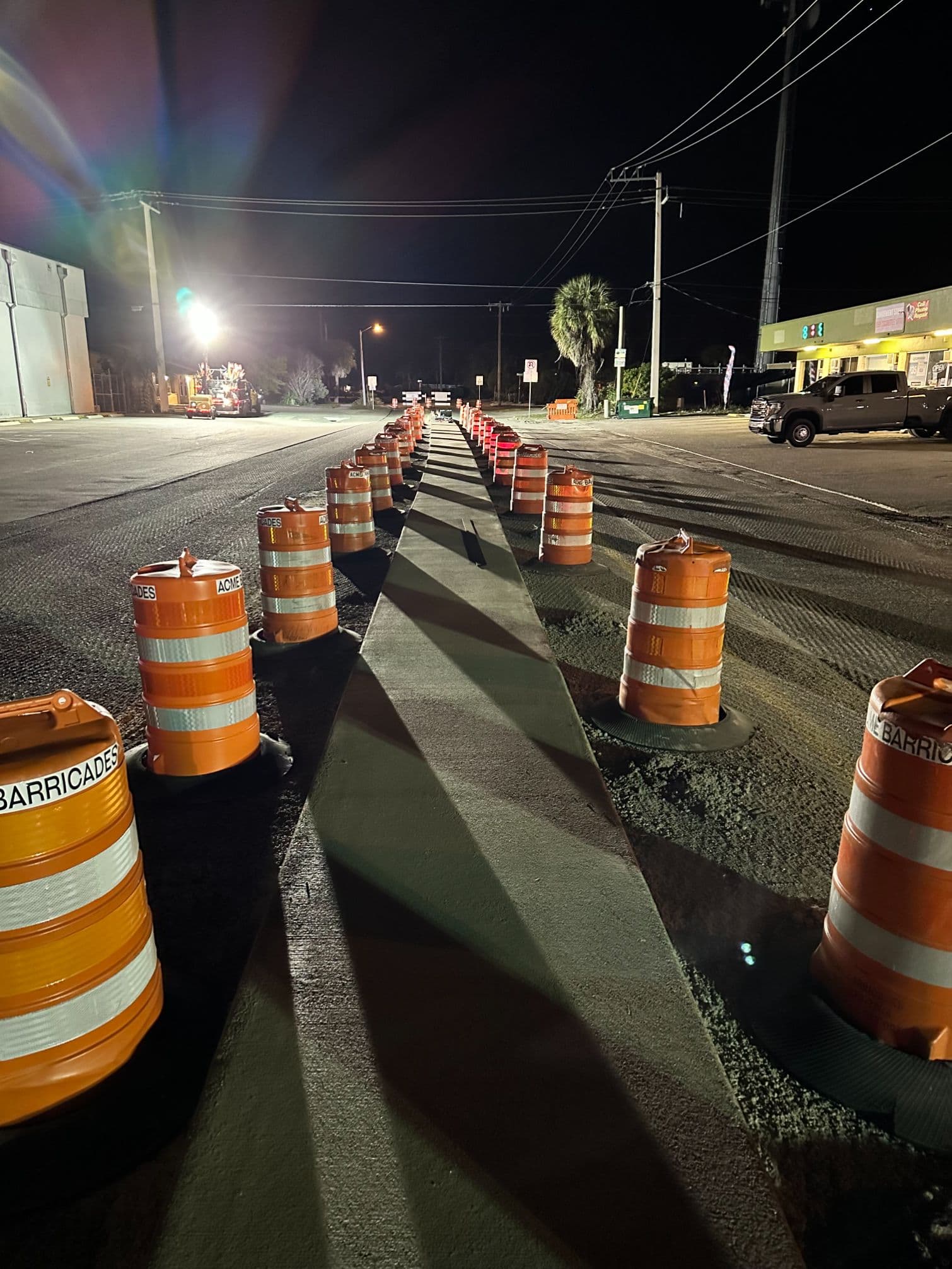 Night-time lane closure lined with barricades over a fresh rapid set concrete repair