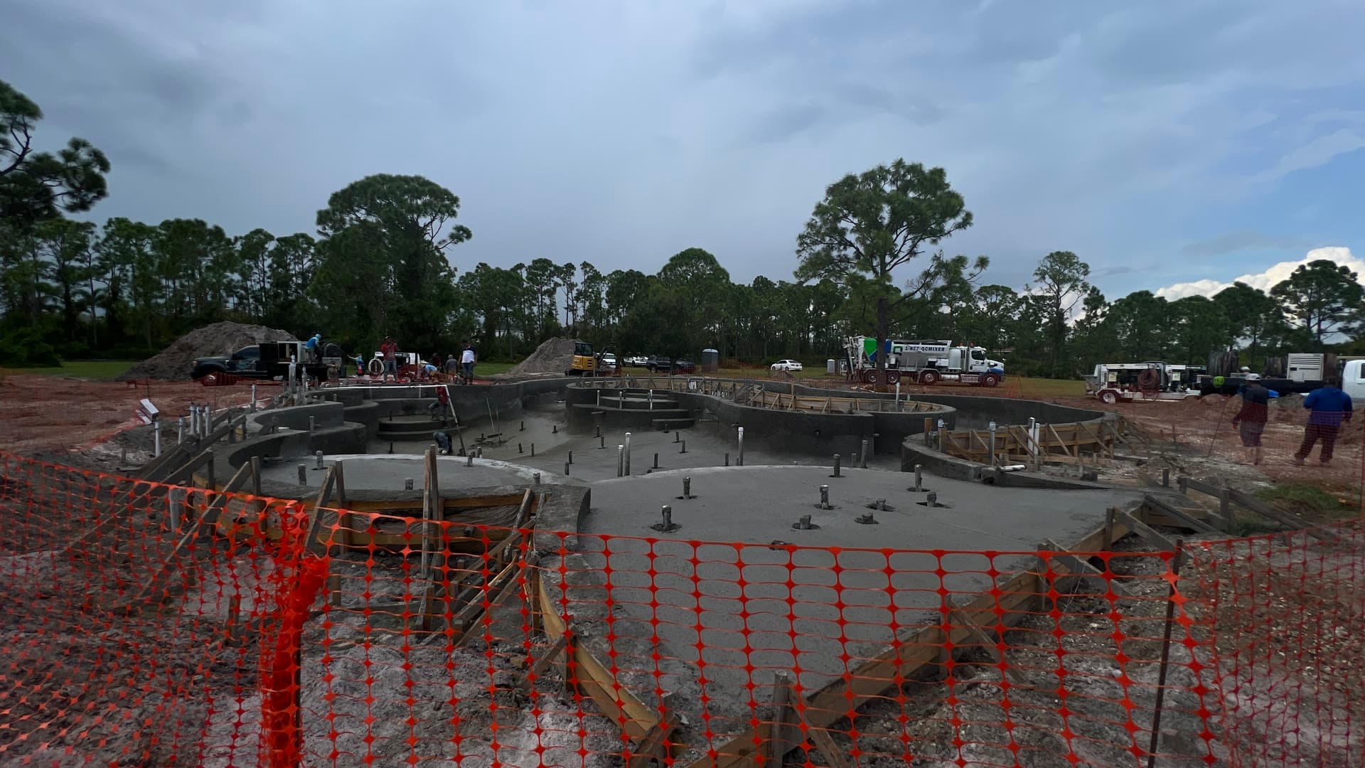 Freeform shotcrete swimming pool shell under construction with a Quality-Crete volumetric mixer truck on site