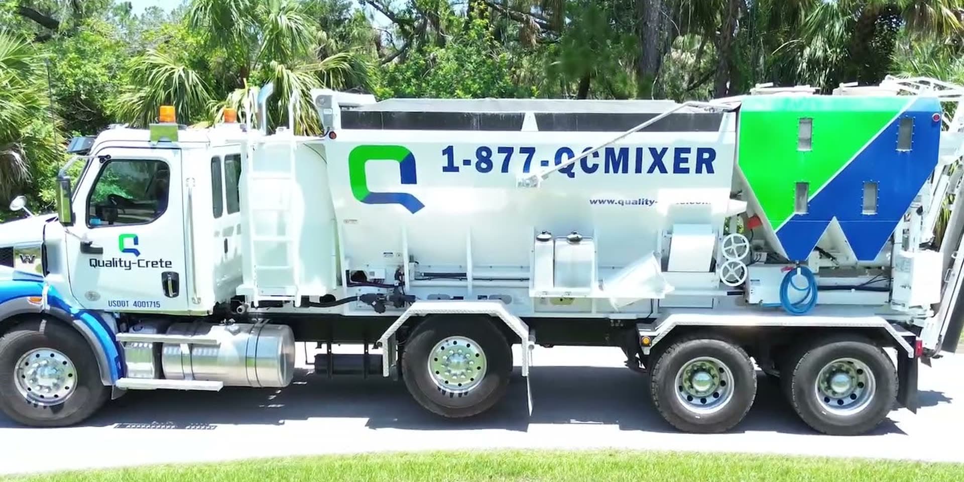 Quality-Crete volumetric mixer truck parked on a palm-lined street